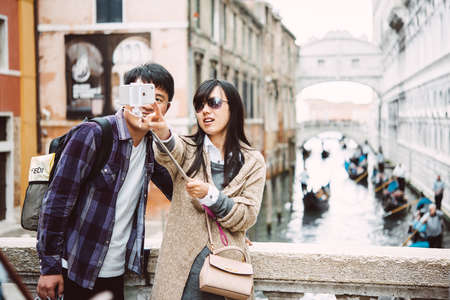 VENICE, ITALY - OCTOBER 12, 2015: Tourists are taking selfie at one of the bridges in Venice, Italyのeditorial素材