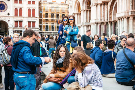 VENICE, ITALY - OCTOBER 12, 2015: Tourists are taking selfie at San Marco square in Venice, Italyのeditorial素材