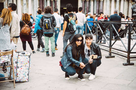 VENICE, ITALY - OCTOBER 12, 2015: Tourists are taking selfie at San Marco square in Venice, Italyのeditorial素材