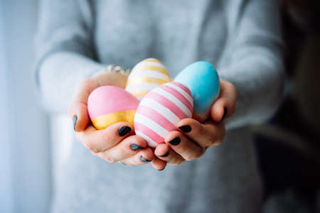 Hands holding modern painted easter eggsの写真素材