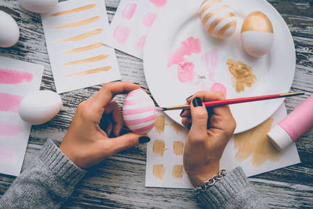 Modern painted easter eggs in hands. Toned pictureの写真素材