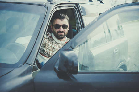 Young man driving the car in the mountains is relaxing at a roadsideの写真素材