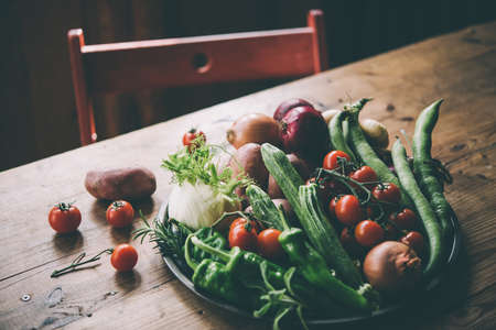 Different fresh farm vegetables on wooden table. Autumn harvest and healthy organic food concept. Toned pictureの写真素材