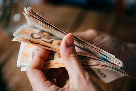 Hands holding european Euro billsの写真素材