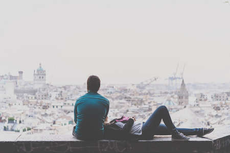 Young couple is relaxing and enjoying the view of the city. Toned pictureの写真素材