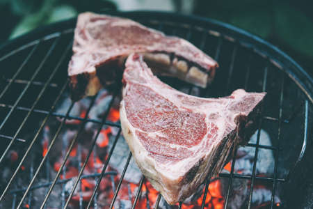 Two ribeye beef steaks on the charcoal grill. Toned pictureの写真素材