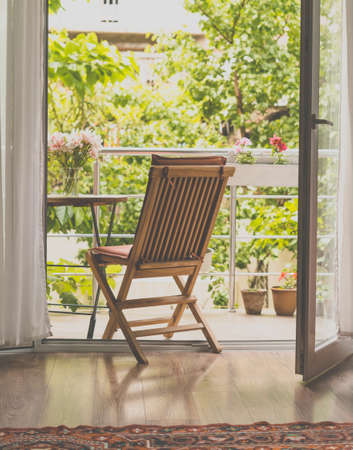 Beautiful terrace or balcony with small table, chair and flowers. Garden view. Toned pictureの写真素材