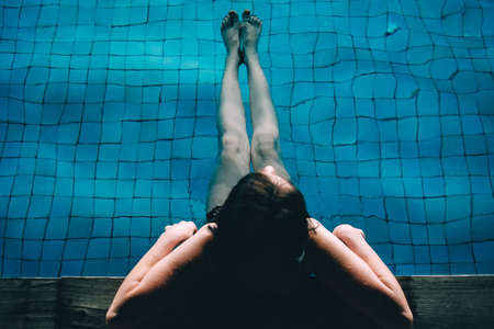 A young pretty woman swims in a pool. Wellness concept. Calmness and relax, woman happiness.の写真素材