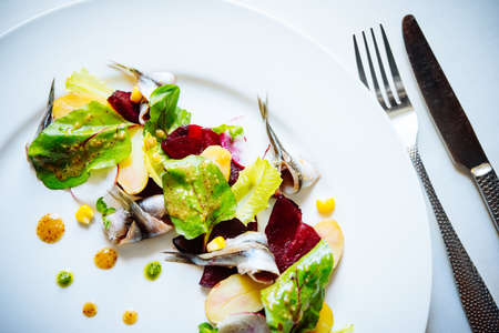 Fresh salad with mackerel, herbs and potatoes served on a plateの写真素材