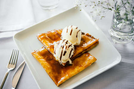 Pancakes with ice cream served on a white plate