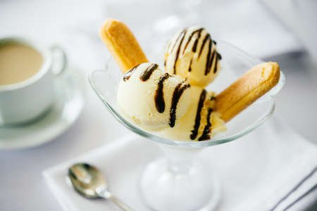 Ice cream with savoiardi cookies served with coffee or tea with milkの写真素材