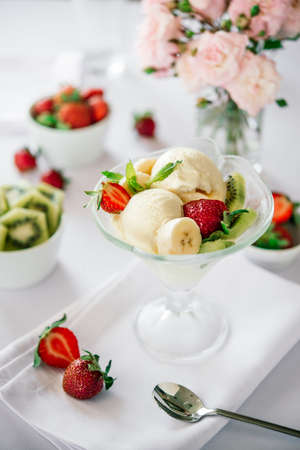 Ice cream with fresh fruits served on whiteの写真素材