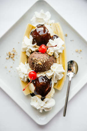Banana split ice cream served on white plateの写真素材