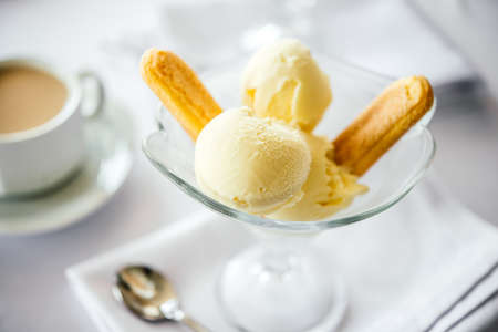 Ice cream with savoiardi cookies served with coffee or tea with milkの写真素材