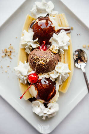 Banana split ice cream served on white plateの写真素材