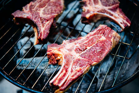 Three aged rib-eye beef meat steaks cooking. Grill and BBQ or barbecue season conceptの写真素材