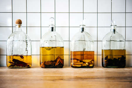 Rustic bottles with homemade liquors or oils with pepper and spices inside.の写真素材