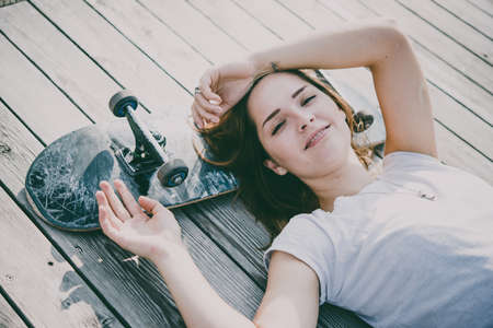 Young girl enjoys skateboarding. Toned pictureの写真素材