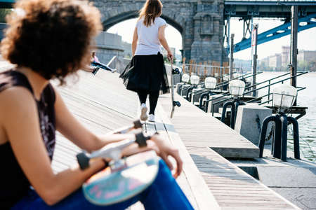 Two young girls enjoy skateboarding in the park in summer. Active live and sport conceptの写真素材