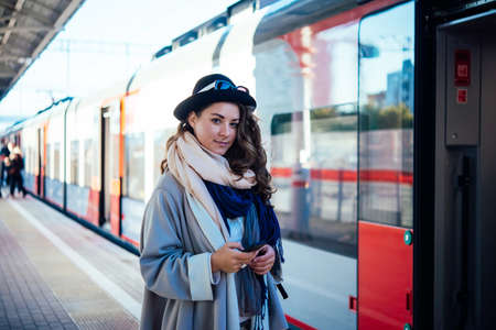 Young beautiful woman stands on the platform while waiting for the train.の写真素材