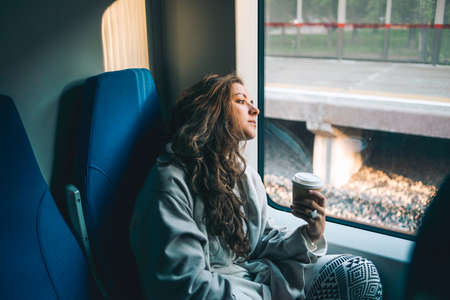Young beautiful woman looking through the train window.の写真素材