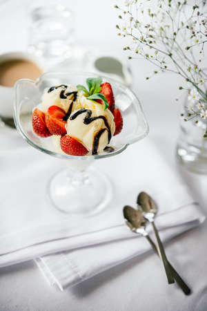Ice cream with strawberries and balsamic on chocolate glaze served on whiteの写真素材