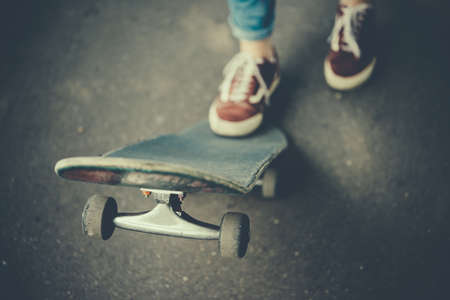 Young girl is holding her skateboard. Toned pictureの写真素材