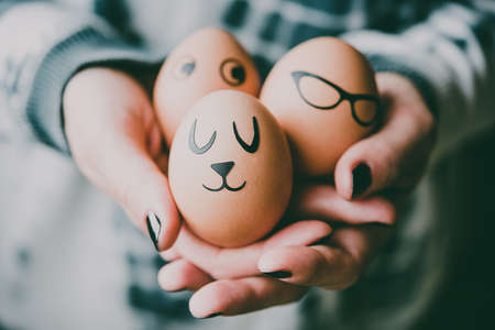 Hands holding modern painted easter eggs. Toned pictureの写真素材