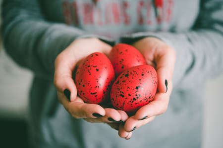 Hands holding modern painted easter eggs. Toned picture