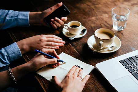 Two women discussing business projects in a cafe while having coffee. Startup and brain storm conceptの写真素材