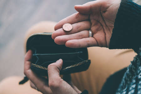 Hands holding euro cent coin and small money pouch. Toned pictureの写真素材