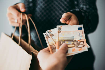 Customer pays euro bills cash while shoppingの写真素材