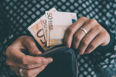 Hands holding euro bills and small money pouch. Toned pictureの写真素材