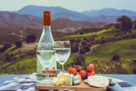 Wine and different appetizers at a picnic in the mountainsの写真素材