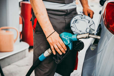 Hand holding fuel pump at a petrol station.の写真素材