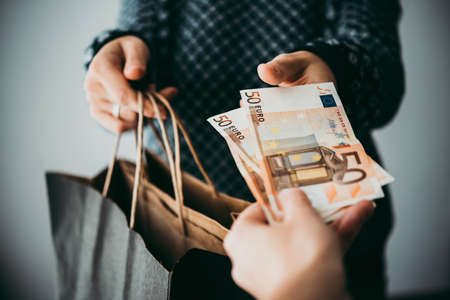 Customer pays euro bills cash while shoppingの写真素材