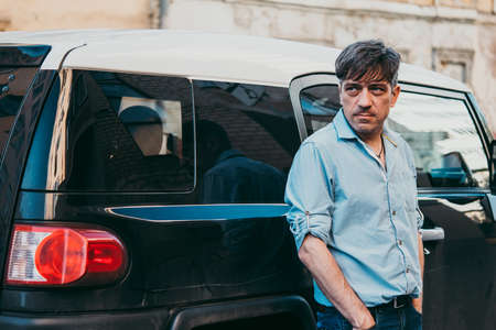 Portrait of a mature confident handsome man standing by his carの写真素材