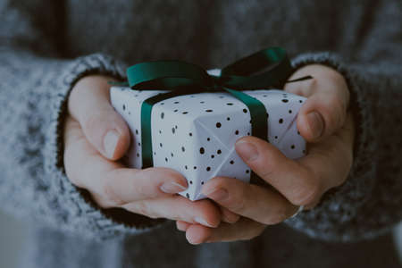 Person holds christmas or new year decorated gift box. Toned pictureの写真素材