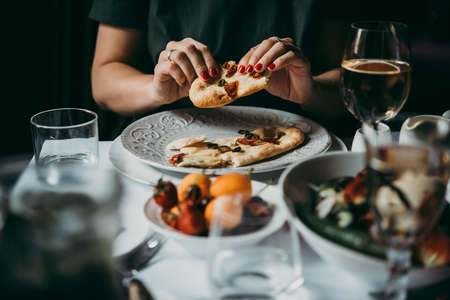 Eating bread or focaccia served during a dinner of a party in a restaurant.の写真素材