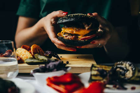 Hands holding a black burgerの写真素材