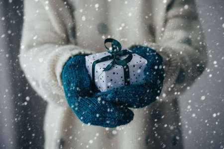 Person holds christmas or new year decorated gift box