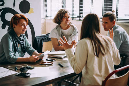 Young women working and communicating together in creative office. Successful feminine teamwork and business brainstorm concept.の写真素材