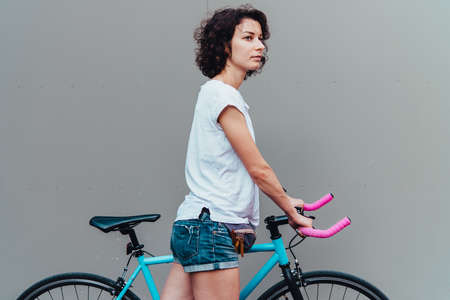 Young beautiful girl walks with her single speed of fixed gear bicycleの写真素材