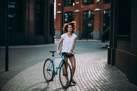 Young beautiful girl walks with her single speed of fixed gear bicycleの写真素材