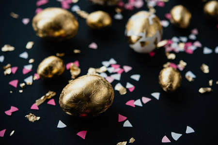 Modern style easter eggs coated with golden foil. on a dark backgroundの写真素材