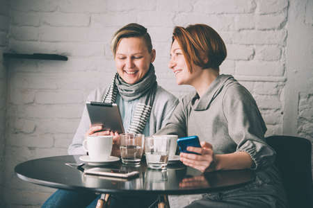 Two women discussing business projects in a cafe while having coffee