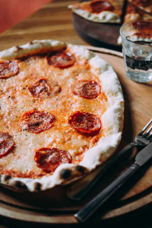 Delicious pizza pepperoni served on a wooden table for dinner.の写真素材