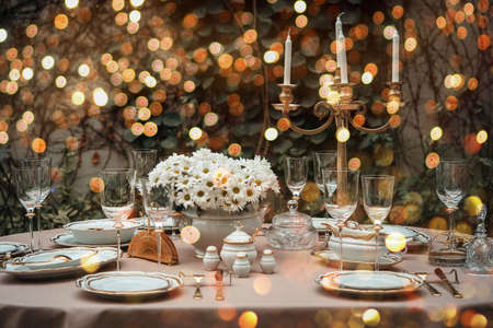 Table served for luxury dinner party lighted with garlandsの写真素材