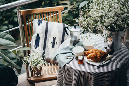 Breakfast with croissants and coffee served on a beautiful terrace or balconyの写真素材