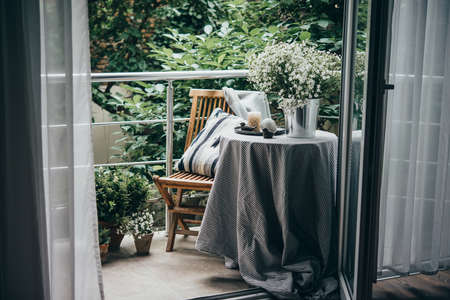 Beautiful terrace or balcony with small table, chair and flowersの写真素材